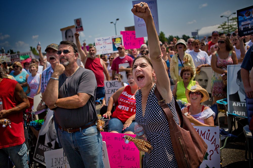 Market Basket workers protest in Tewksbury last month. Workers, are relieved that beloved former CEO Artie T. Demoulas is back in control of the grocery chain after Wednesday's late night deal. (Jesse Costa/WBUR)