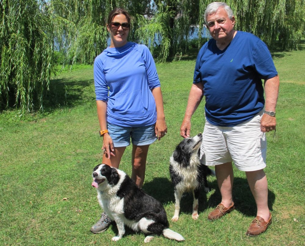 Len Ellis with his daughter Amy on the Esplanade. Lynn and Flo, border collies, sit at their feet. (Virginia Marshall/WBUR)