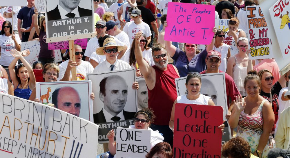 Paul G. Pustorino: "The Demoulas family has the ability to set an example that transcends their private issues. Their next step may be a defining moment in New England business history." Pictured: Protesters hold signs during a rally at Market Basket in Tewksbury, Mass., Tuesday, Aug. 5, 2014. (Elise Amendola/AP)