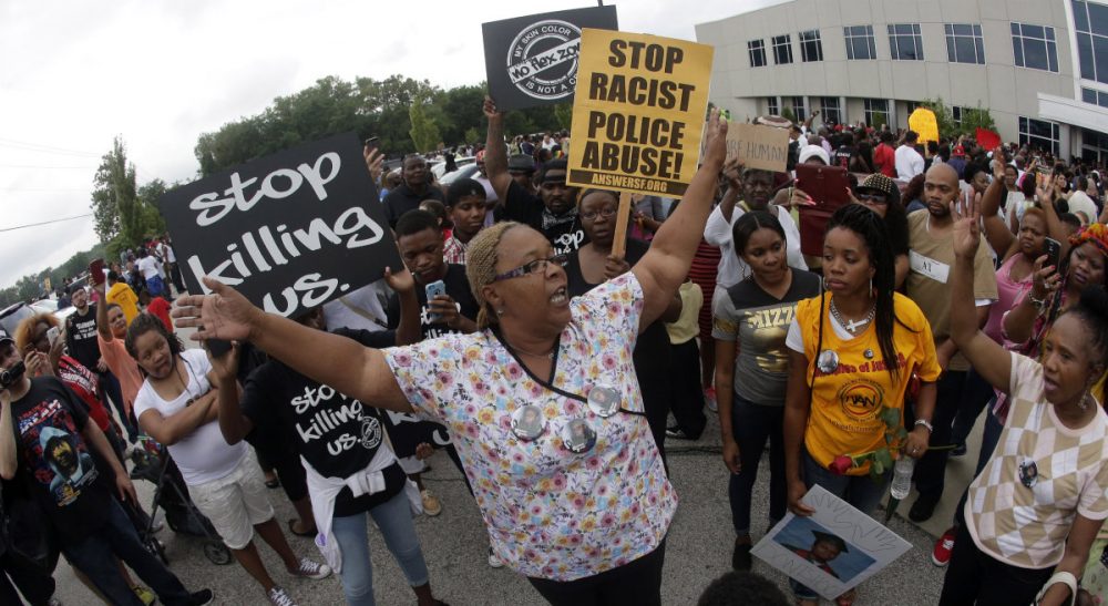 Carol Rose and Carl Williams: "Police who stop or search people based on race rather than evidence of criminal activity are not keeping us safe. Arming police as if they were waging a war against their fellow Americans does not keep us free." Pictured: Helen Shaw talks to people during a rally outside Greater Grace Church, Sunday, August 17, 2014, for Michael Brown Jr. (Charlie Riedel/AP)