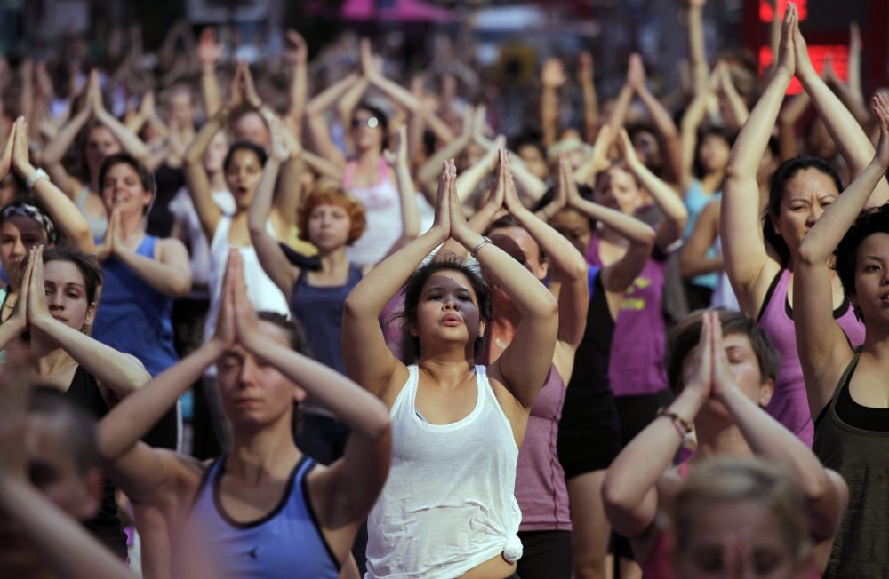 Anita Diamant: "His approach -- making yoga accessible to everybody -- is not sweaty or sexy. Which isn’t to say that it’s easy." Pictured: Thousands of yoga enthusiasts convene in New York's Times Square to mark the summer solstice, Wednesday, June 20, 2012. (Mark Lennihan/AP)