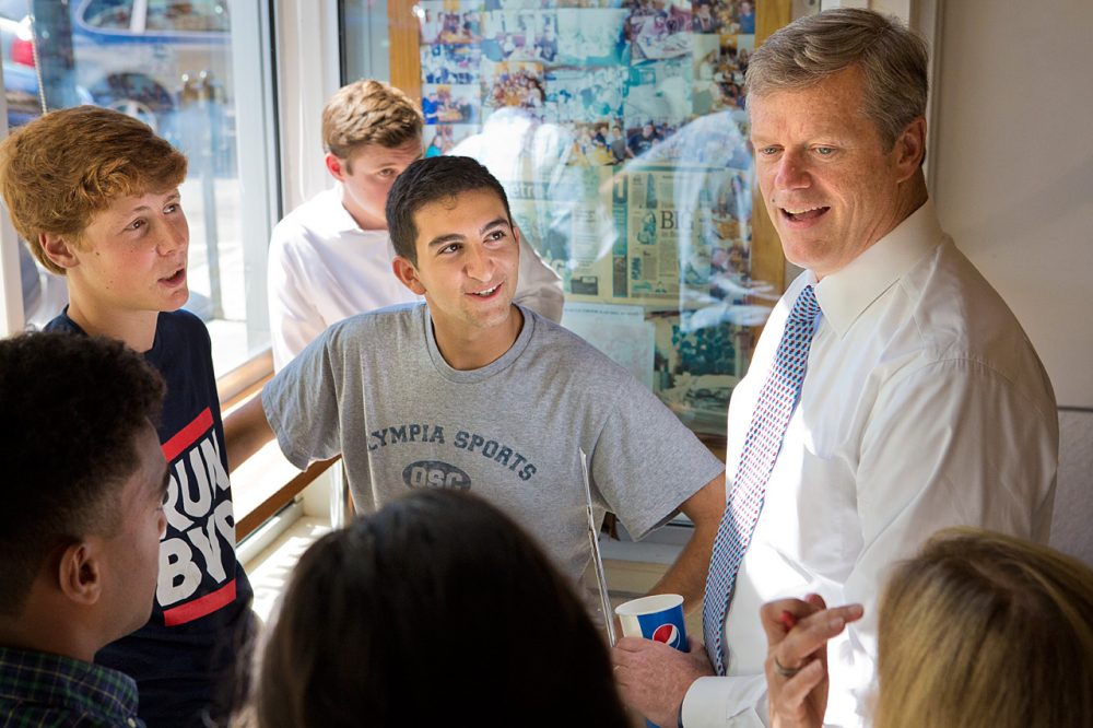Republican Charlie Baker talks with a group of young people in Eagle’s Deli in Boston. (Jesse Costa/WBUR)