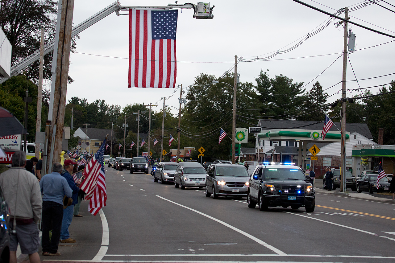 The funeral procession rides through Northborough Center. (Jesse Costa/WBUR)