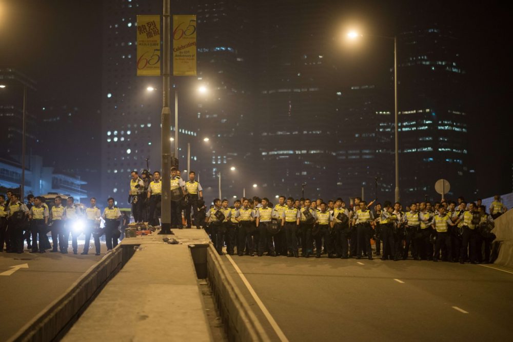 Police prepare to confront pro-democracy protesters outside the central government offices in the Admiralty district of Hong Kong on October 15, 2014. Hong Kong police vowed October 14 to tear down more street barricades manned by pro-democracy protesters, hours after hundreds of officers armed with chainsaws and boltcutters partially cleared two major roads occupied for a fortnight. (Ed Jones/AFP/Getty Images)