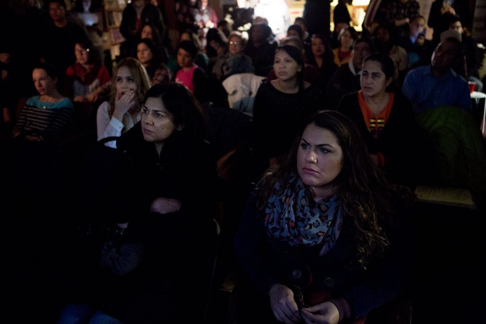 With a subdued but hopeful group, Leila Santana and her daughter Lara of Medford (in front) watch President Obama’s televised address to the nation announcing his executive action on immigration at the Student Immigrant Movement offices in Boston. (Jesse Costa/WBUR)