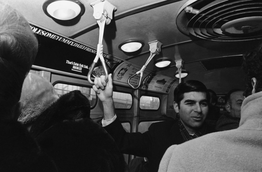 Former Massachusetts Gov. Michael Dukakis was known for taking public transit to work during his time in office. Here, he talks to commuters on a streetcar from Brookline to Boston in 1975. (AP)