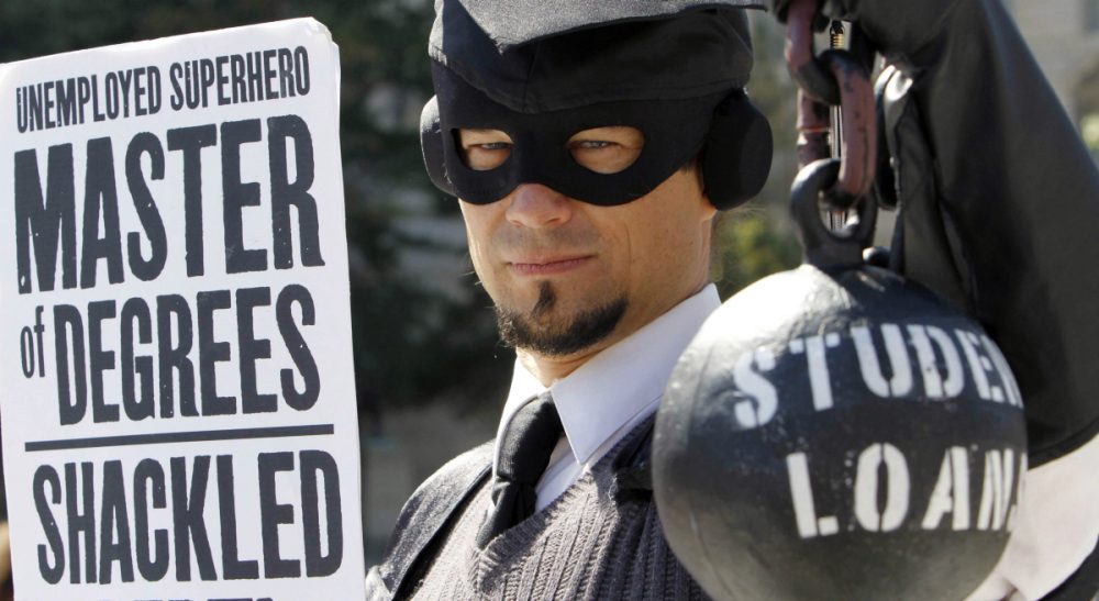 A millenial holds a ball and chain representing his college loan debt, during a protest in Washington, D. C. Two-thirds of college graduates aged 30 and under finished school with loan debt averaging $21,000. (Jacquelyn Martin, AP)
