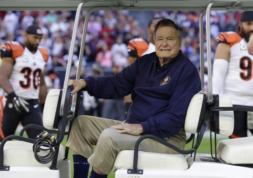 Former president George H. W. Bush takes part in the coin toss prior to an NFL football game between the Houston Texans and Cincinnati Bengals, on Nov. 23, 2014, in Houston. (David J. Phillip/AP)