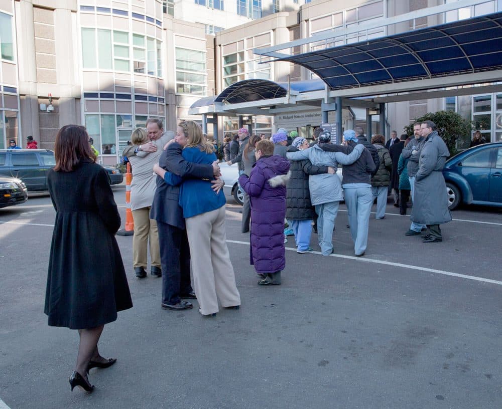 Brigham and Women's Hospital staff embrace after a ceremony remembering Dr. Michael Davidson on Wednesday. (Robin Lubbock/WBUR)