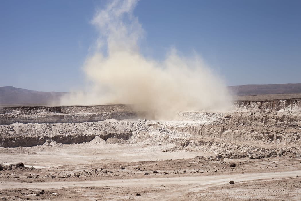 A still from Allison Cekala’s video shows dynamite blasting in the Chilean mine throwing clouds of dust into the air. (Allison Cekala)