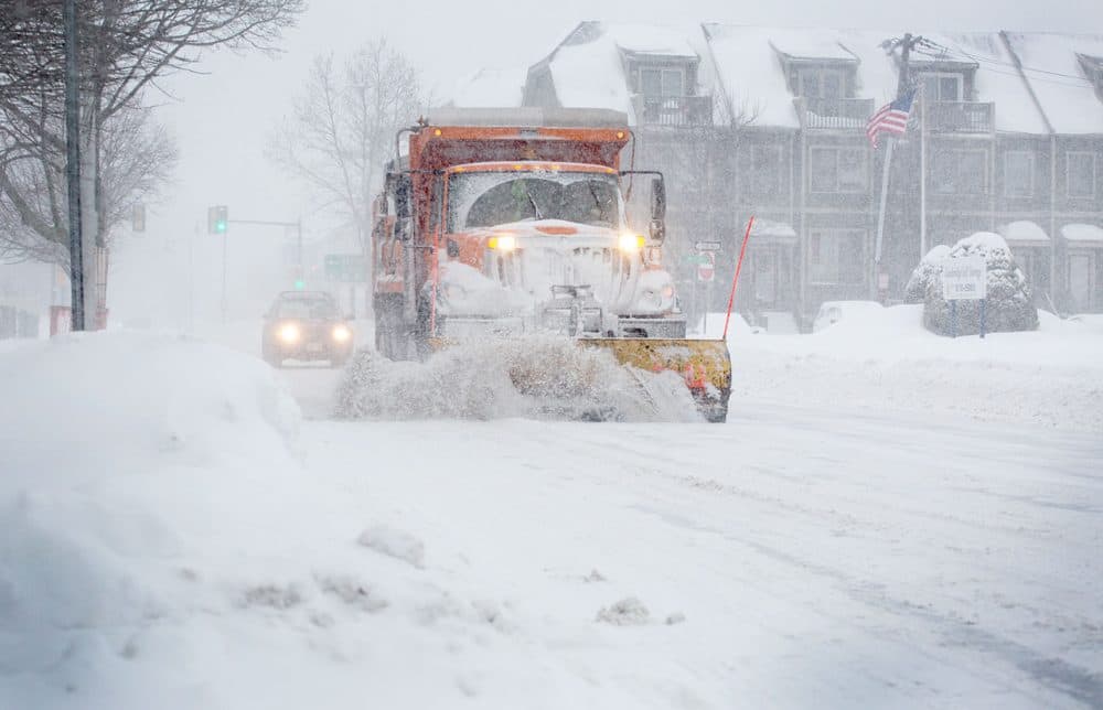 A snow plow works down Concord Avenue during the morning commute.