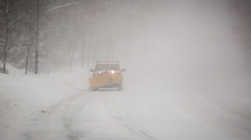 A snow plow drives on Fresh Pond Parkway in Cambridge Sunday morning. (Robin Lubbock/WBUR)
