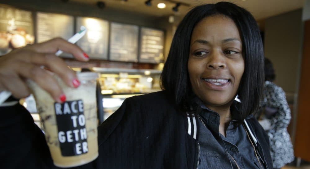 Wendy Kaminer: Important conversations often occur naturally in public spaces like Starbucks, but they are rarely about important subjects. In this March 18, 2015 file photo, Larenda Myres holds an iced coffee drink with a "Race Together" sticker on it at a Starbucks store in Seattle. Starbucks baristas will no longer write "Race Together" on customers' cups starting Sunday, ending as planned a visible component of the company's diversity and racial inequality campaign that had sparked widespread criticism in the week since it took effect. (Ted S. Warren/AP)