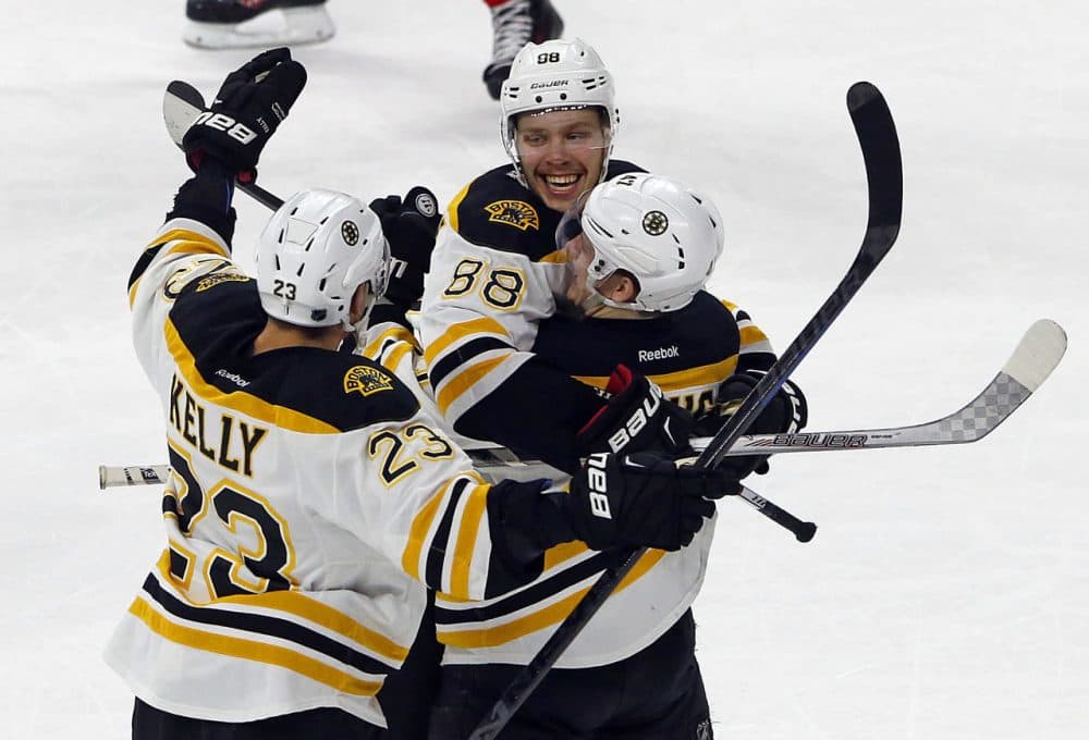 Boston's David Pastrnak (88) celebrates his game-winning overtime goal with teammates Torey Krug (47), and Chris Kelly (23). (Karl B DeBlaker/AP)