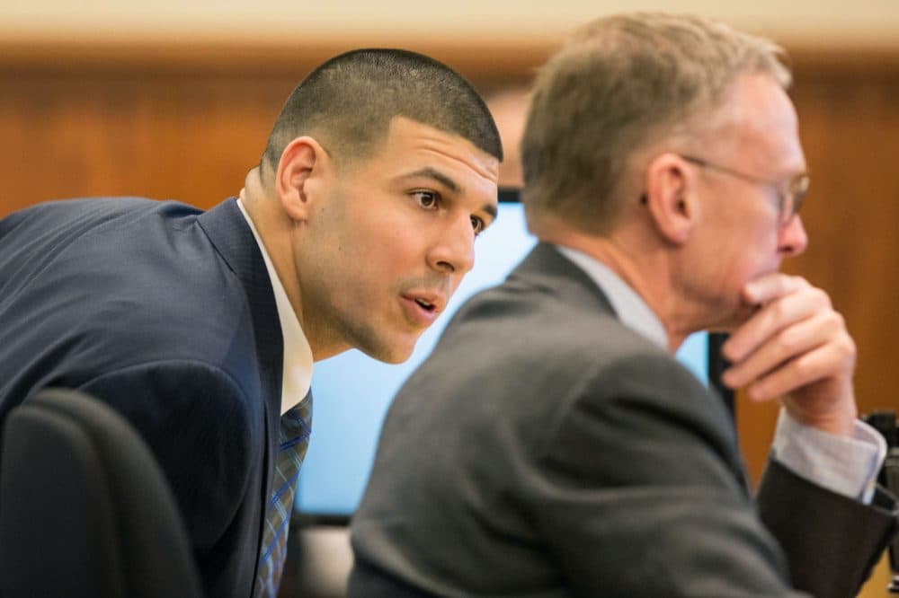 Aaron Hernandez, left, speaks with his attorney during testimony Monday. (Aram Boghosian/The Boston Globe/Pool)