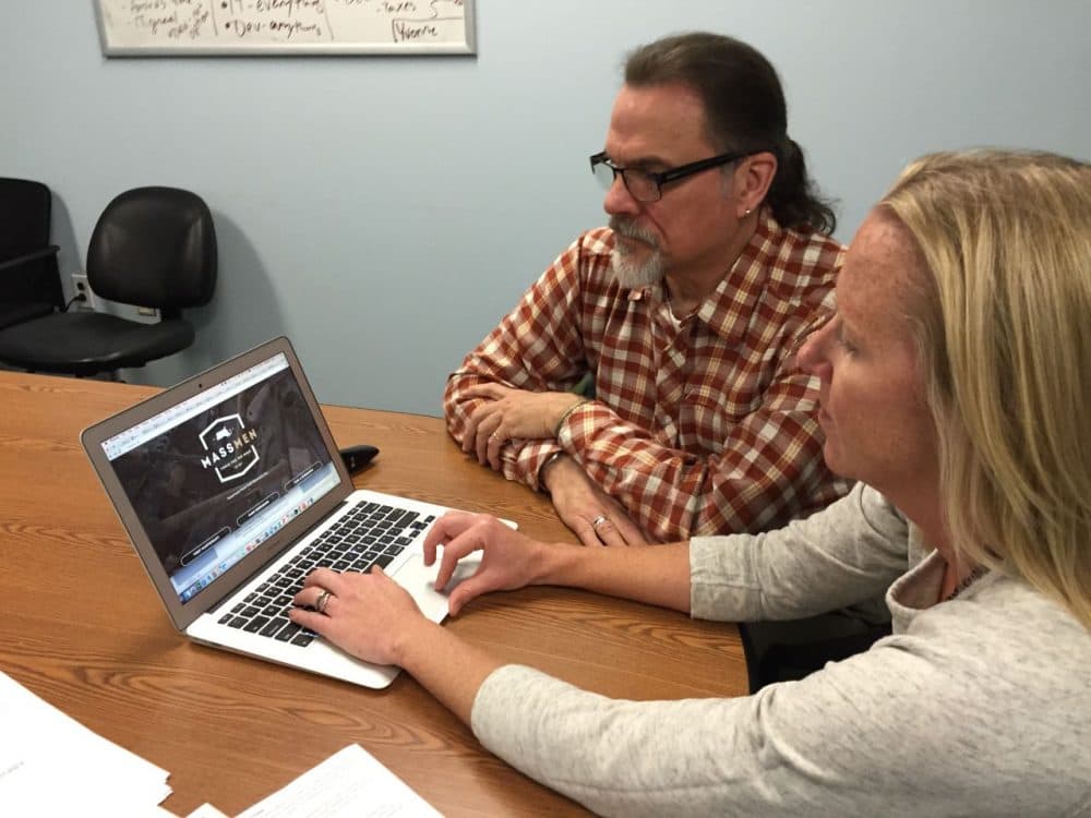 Franklin Cook, project manager of the MassMen campaign, and Candice Porter, executive director of Screening for Mental Health, using the MassMen website. (Lynn Jolicoeur/WBUR)