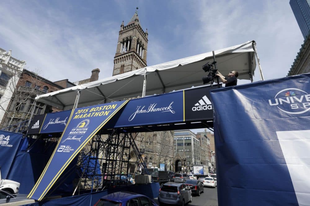 A worker adjusts lights on the photo bridge near the Boston Marathon finish line Thursday, April 16, 2015, on Boylston Street in Boston. The 119th Boston Marathon will be run on Monday. (Steven Senne/AP)