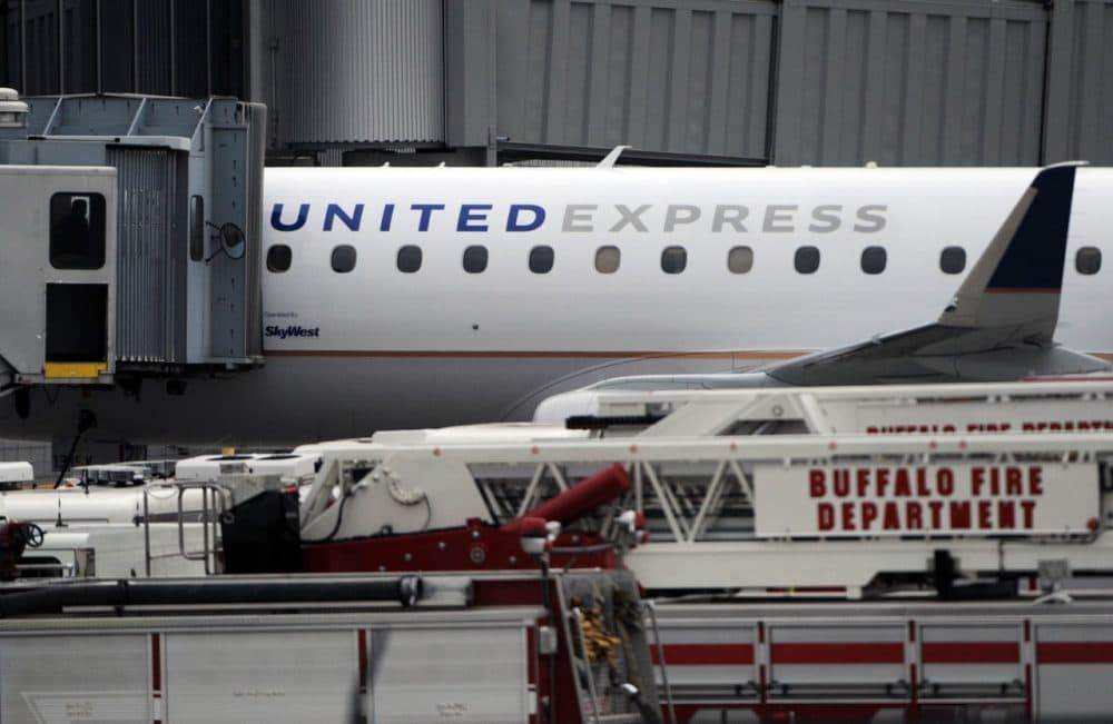 Emergency vehicles surround a SkyWest Airlines plane, operating as United Express, that made an emergency landing at Buffalo Niagara International Airport, Wednesday, April 22, 2015, in Cheektowaga, N.Y. A SkyWest spokeswoman said one passenger aboard Flight 5622, lost consciousness and the pilots rapidly descended "out of an abundance of caution." (Gary Wiepert/AP)
