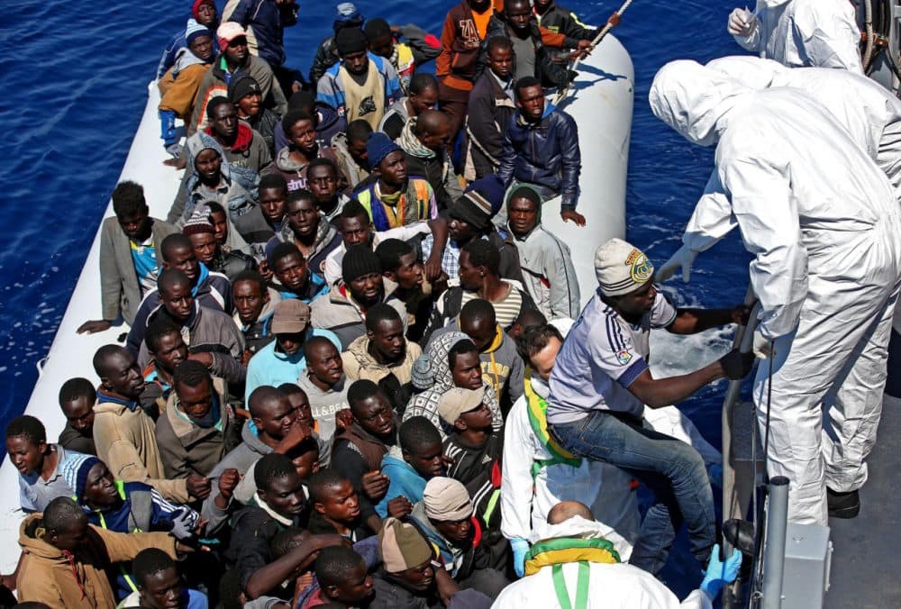 In this photo from April 22, 2015, migrants crowd and inflatable dinghy as rescue vassel " Denaro " of the Italian Coast Guard approaches them, off the Libyan coast, in the Mediterranean Sea. (Alessandro Di Meo/ANSA via AP)