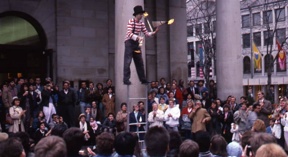 The managers of Faneuil Hall Marketplace are demanding that artists there pay between $500 and $2,500 for the privilege of earning tips and vending small wares. In this 1988 archive photo, a juggler performs at Faneuil Hall Marketplace. (Peter H. Dreyer/City of Boston Archives)