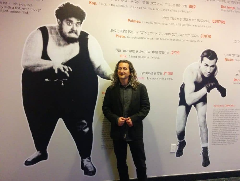 Eddy Portnoy poses with the exhibit he curated on Yiddish street fighting as well as Jewish wrestlers in Europe and the U.S. including Martin Levy (left), who weighed in at over 600 pounds and was aptly nicknamed, "The Blimp."