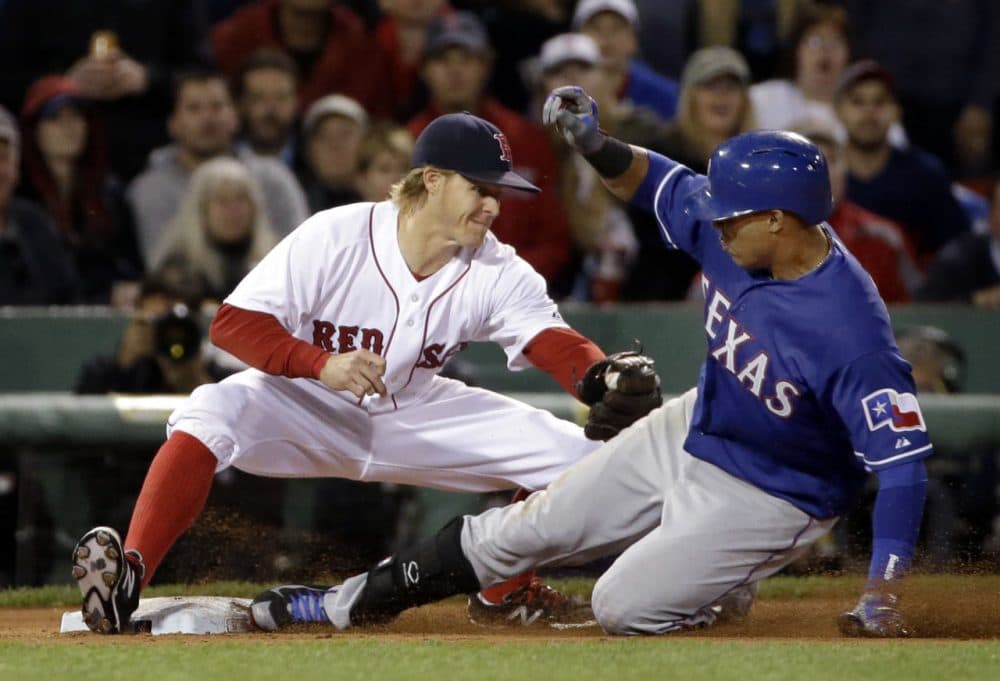 Texas Rangers' Leonys Martin slides into third base as Boston Red Sox third baseman Brock Holt attempts a tag during the seventh inning at Fenway Park on Wednesday, May 20, 2015. (Elise Amendola/Associated Press)