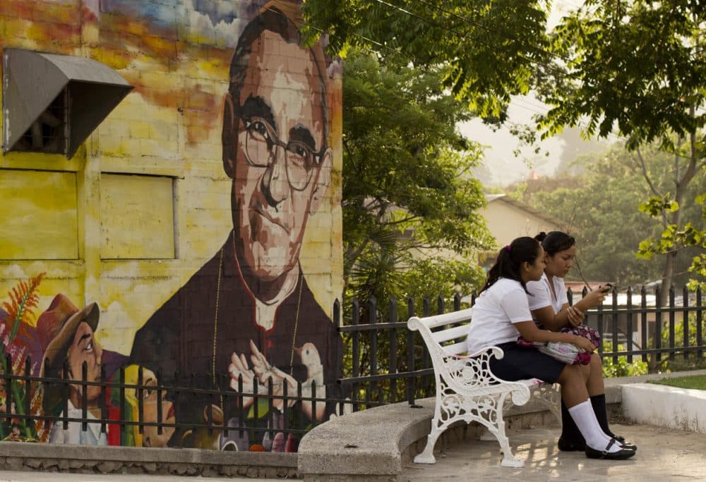 A mural of Roman Catholic Archbishop Oscar Romero decorates a wall where students sit in a plaza in Panchimalco, El Salvador, Thursday, May 21, 2015. (Salvador Melendez/AP)
