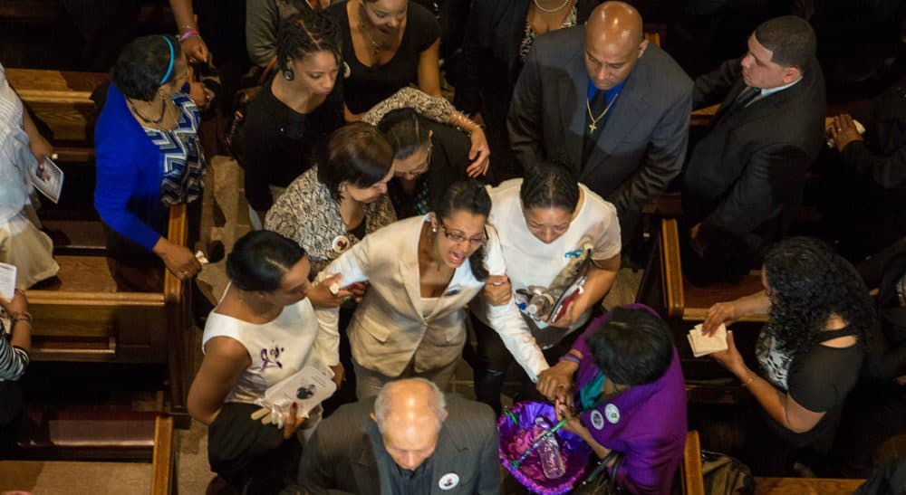 In this photo, friends and relatives comfort Laura Fatima Dos Santos as her son Jonathan's casket is ushered out of St Peter’s Parish Church in Dorchester, Thursday, June 18, 2015. Police say two fellow teens “trapped” 16-year-old Jonathan as he was riding his bike, and then shot him five times. (Jesse Costa/WBUR)