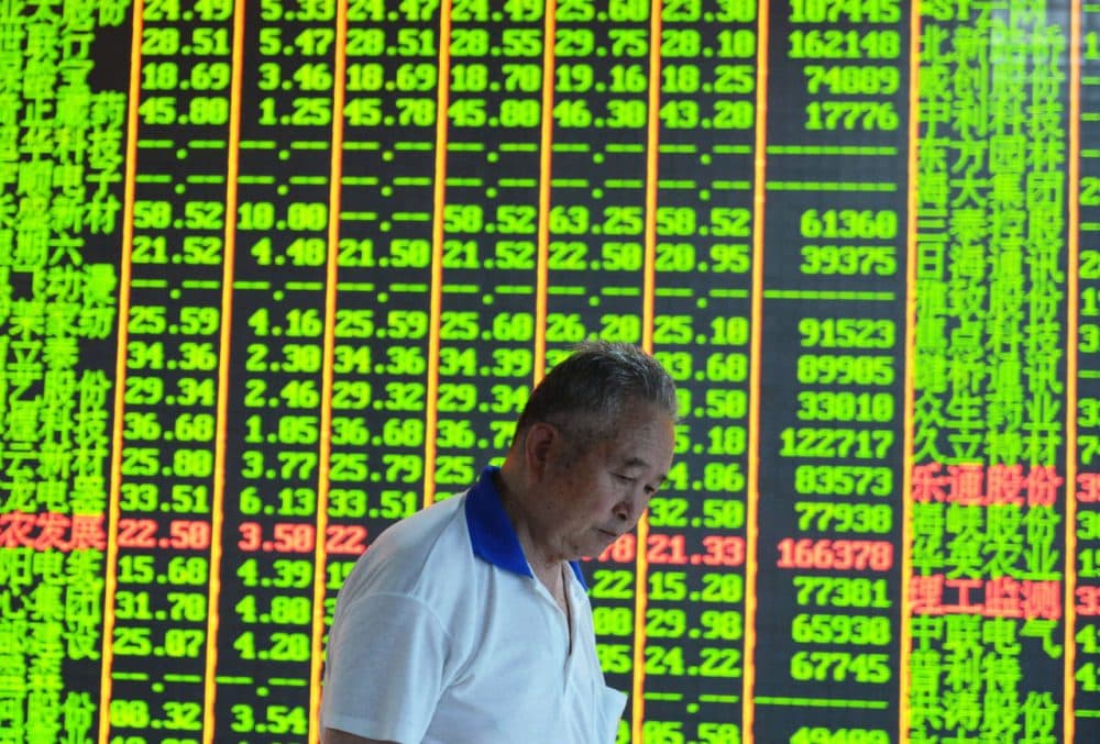 An investor walks past a share prices board at a security firm in Hangzhou, eastern China's Zhejiang province on June 30, 2015. (STR/AFP/Getty Images)