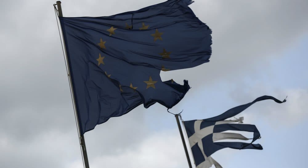 Alex Green: "Unless the structure of the Eurozone is changed, similar crises will tend in the same direction, and if that is the case, the question arises: What is a government for?"
Pictured: Ruined EU and Greek flags fly in tatters from a flag pole at a beach at Anavissos village, southwest of Athens. (Yorgos Karahalis/AP)