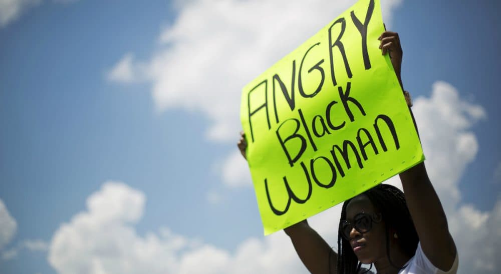 Michael Lueger: "The best that we can do is to attempt to call events by their proper names, and to ensure that future generations do not forget their lessons." Pictured: A woman who gave her name as Sista Solove holds a sign outside the bond hearing for the suspected gunman in the shooting Wednesday that left nine people dead at Emanuel AME Church, Friday, June 19, 2015, in North Charleston, S.C. (David Goldman/AP)