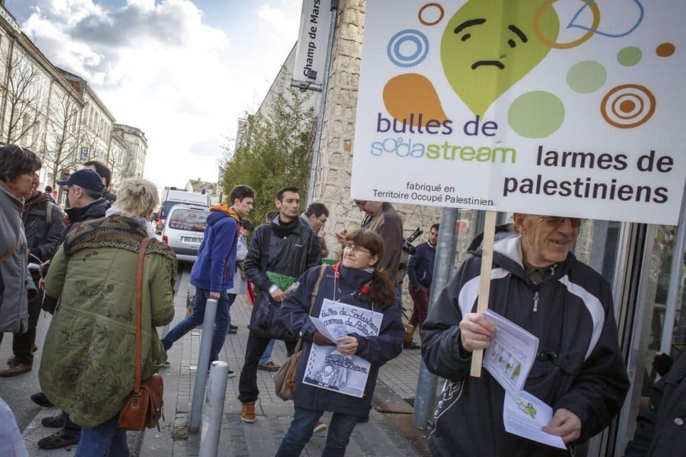 A man holds a placard reading "Bubbles of Sodastream, Tears of Palestinians" during a demonstration in France earlier this year. (Pierre Duffour/AFP/Getty Images)