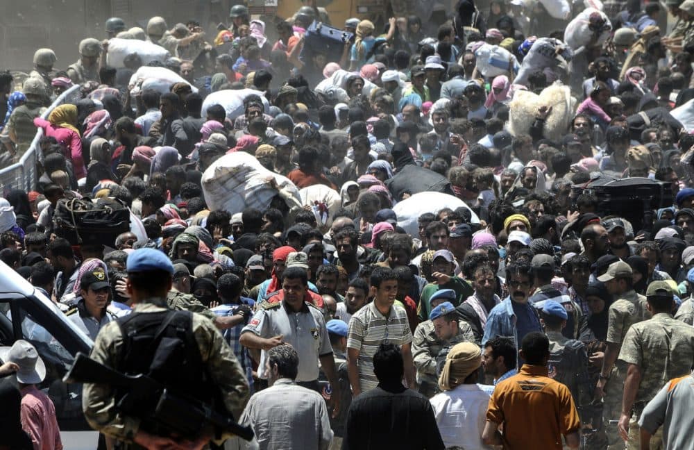Syrian refugees wait for transportation at the border between Syria and Turkey after crossing over from the Syrian town of Tal Abyad, near Akcakale in Sanliurfa province, on June 10, 2015. (STR/AFP/Getty Images)