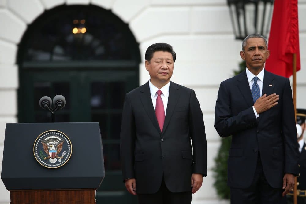 U.S. President Barack Obama (R) and Chinese President Xi Jinping (C) listen to their national anthems during in Washington D.C. Jinping will unveil a cap-and-trade program Friday. (Win McNamee/Getty Images)