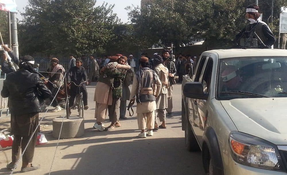 Taliban fighters hug each other a day after they overran the strategic northern city of Kunduz, on September 29, 2015. (STR/AFP/Getty Images)