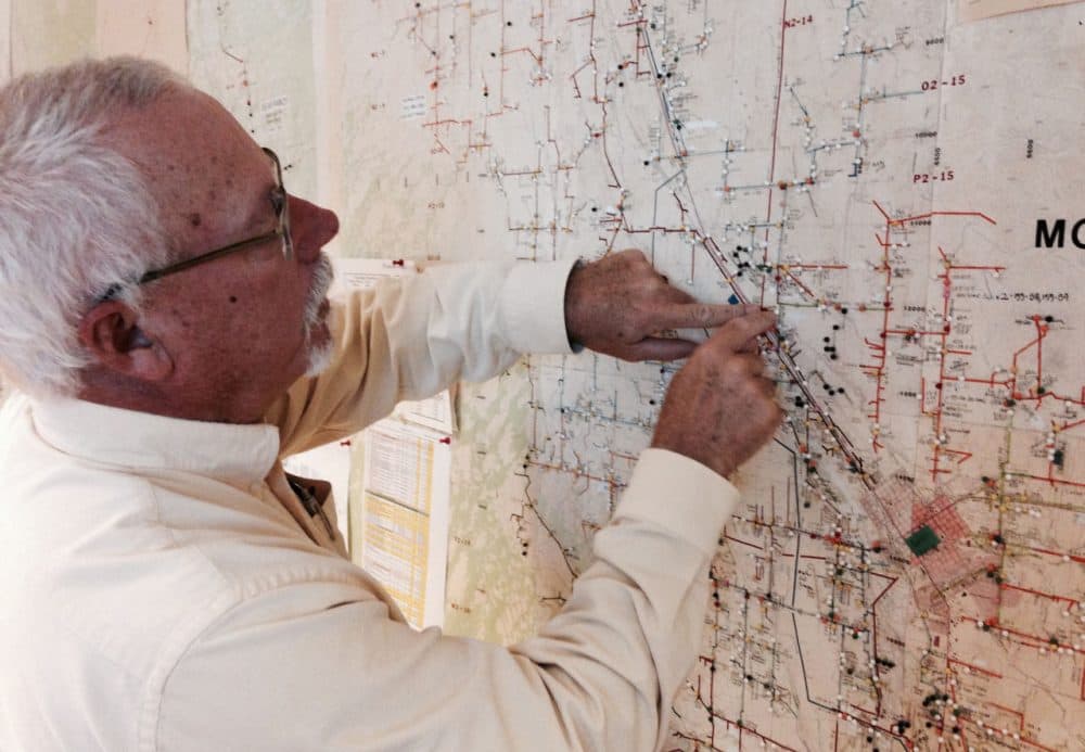 Steve Metheny of the Delta-Montrose Electric Association illustrates the utility's back-up to the back-up: a floor to ceiling paper map of their service area and infrastructure. (Jordan Wirfs-Brock/Inside Energy)