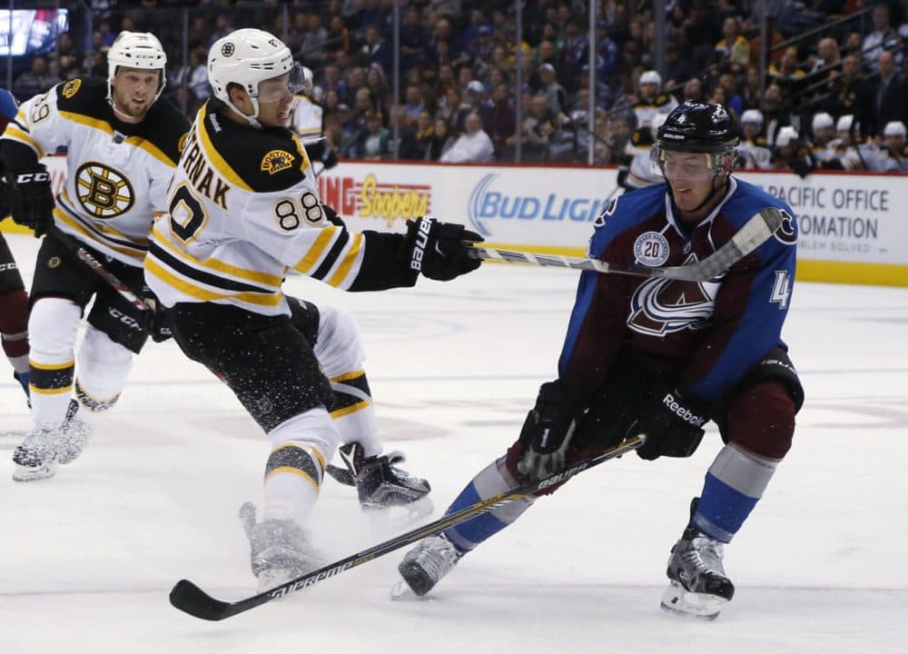 Boston Bruins left wing David Pastrnak, left, of the Czech Republic, shoots past Colorado Avalanche defenseman Tyson Barrie during the game last night in Denver. (David Zalubowski/AP)