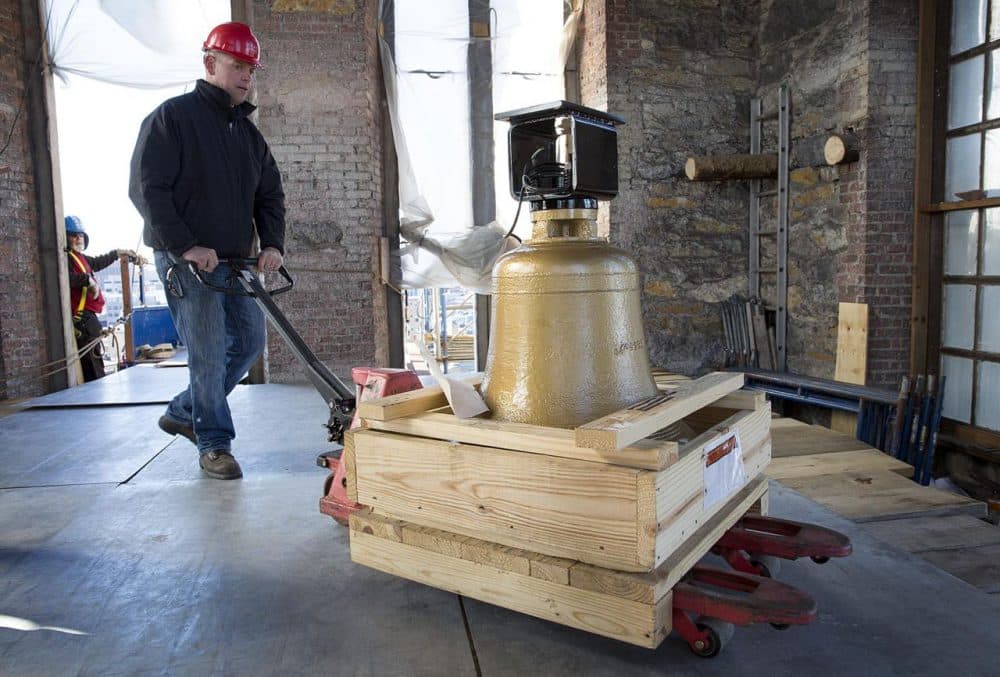 Construction manager Patrick Folan wheels a bell into the bell tower of the Cathedral of the Holy Cross. (Robin Lubbock/WBUR)
