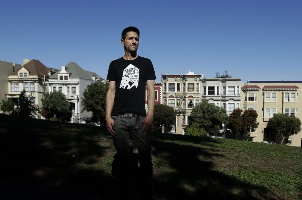 Michael Rouppet poses for photos at Alamo Square Park, Oct. 20, 2015, across the street from the home he was evicted from in San Francisco. Travelers worldwide love using Airbnb to book vacation stays in San Francisco, but some in the city where the company was founded are decidedly less affectionate, backing a Nov. 3 ballot measure that would limit how long a private home can be rented out. (Jeff Chiu/AP)