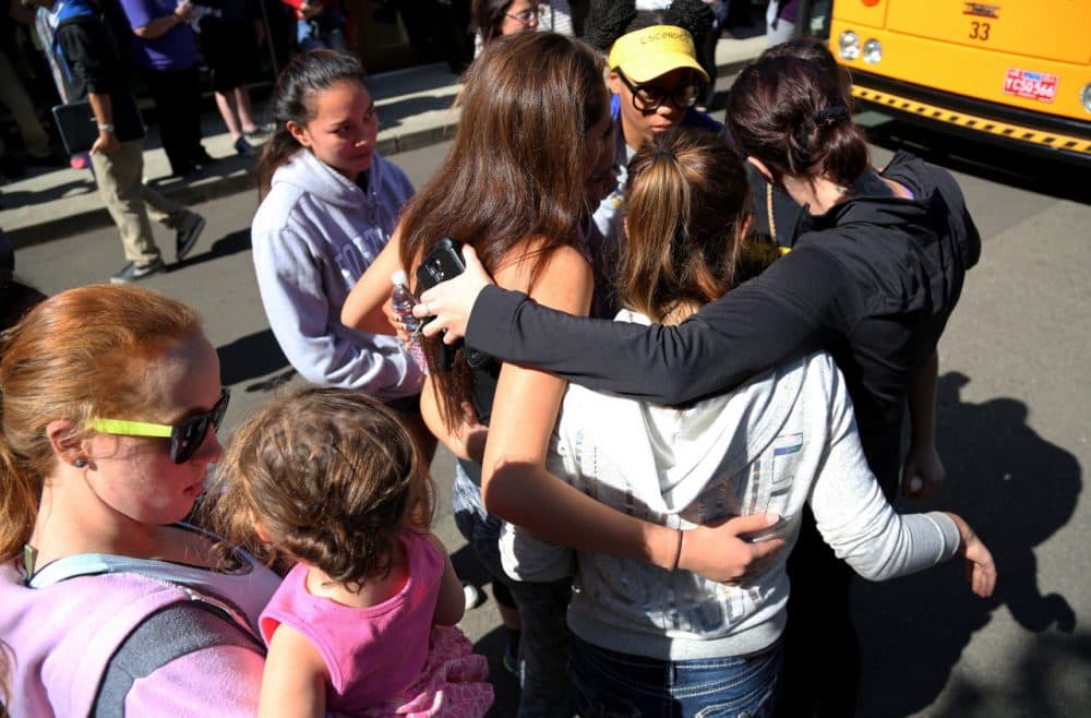 Friends and family are reunited with students at the local fairgrounds after a deadly shooting at Umpqua Community College in Oregon Thursday. (Ryan Kang/AP)