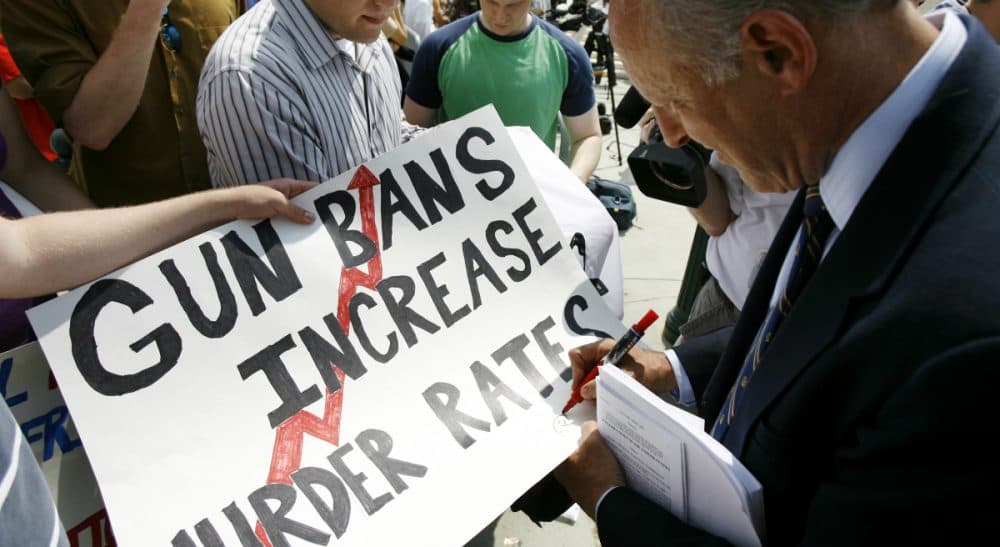 Andrew Grainger: "The recent school shooting in Oregon is one of 14 mass murders that have claimed 125 lives since 2009 and that were committed with legally purchased weapons." Pictured: Dick Heller, the plaintiff in Heller v. District of Columbia, signs an autograph outside the Supreme Court in Washington, Thursday, June 26, 2008, after the court's ruling that Americans have a constitutional right to keep guns in their homes for self-defense, the justices' first major pronouncement on gun control in U.S. history. (Jose Luis Magana/AP)