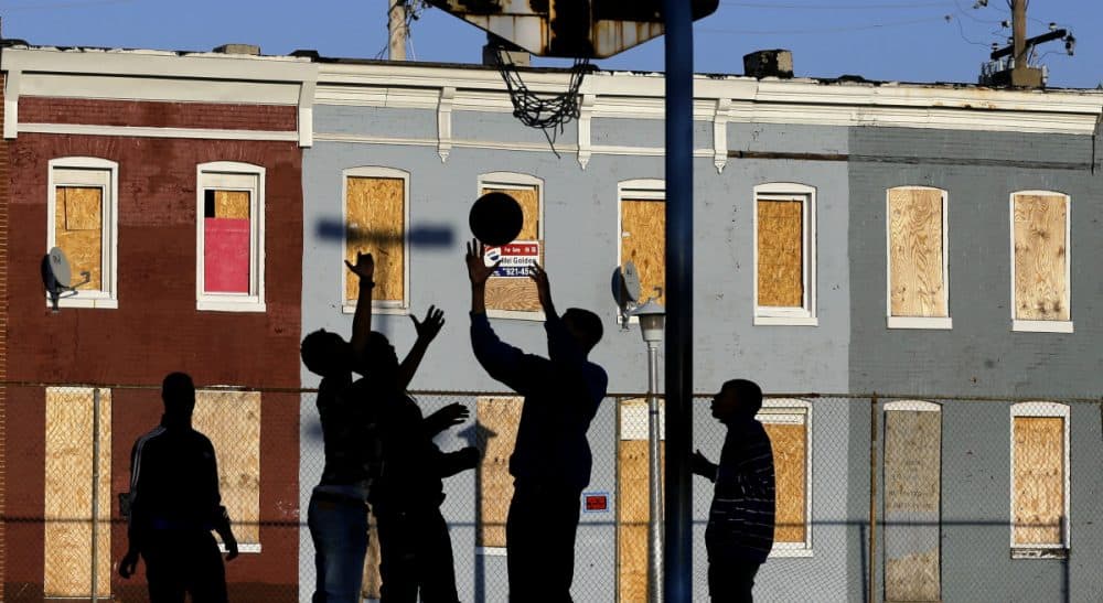 Countless Americans are living on virtually no income. The shocking fact of these families and the complex strategies they use to survive is a national disgrace, says Renée Loth. In this photo, children play basketball at a park near blighted row houses in Baltimore, Monday, April 1, 2013. (Patrick Semansky/ AP)