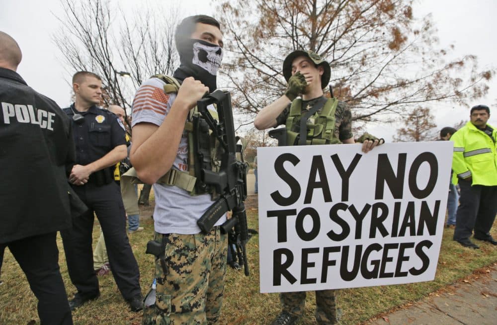 As police stand guard, armed anti-Muslim protestors stand across the street from a mosque during a demonstration in Richardson, Texas, on Saturday, Dec. 12. (LM Otero/AP)