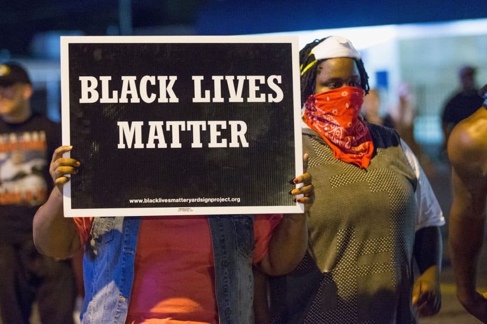Demonstrators, marking the one-year anniversary of the shooting of Michael Brown, protest along West Florrisant Street on August 10, 2015 in Ferguson, Missouri. Brown was shot and killed by a Ferguson police officer on August 9, 2014. His death sparked months of sometimes violent protests in Ferguson and drew nationwide focus on police treatment of black suspects. (Scott Olson/Getty Images)