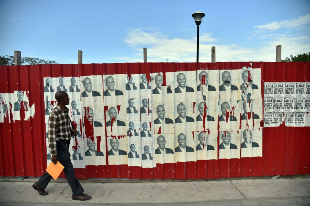A man walks past election posters of presidential candidate Jovenel Moise of the PHTK political party, in front of the National Palace in Port-au-Prince, on January 21, 2016.
The second round of presidential elections is scheduled for January 24 between ruling party candidate Jovenel Moise and Jude Celestin. Celestin has said he does not want to participate in the January 24 run-off against Moise, who has yet to submit his official resignation to the Provisional Electoral Council (CEP). (Hector Retamal/AFP/Getty Images)