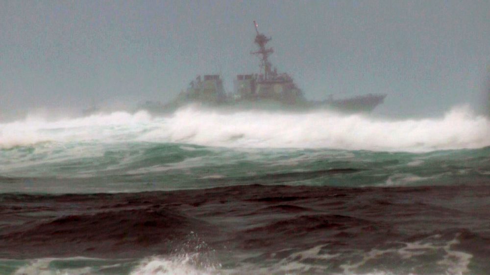 A search vessel cruises the waters off the beach at Haleiwa, Hawaii, on Friday. Two Marine helicopters carrying 12 crew members collided off the island of Oahu during a nighttime training mission, and rescuers are searching a debris field in choppy waters, military officials said. (Audrey McAvoy/AP)