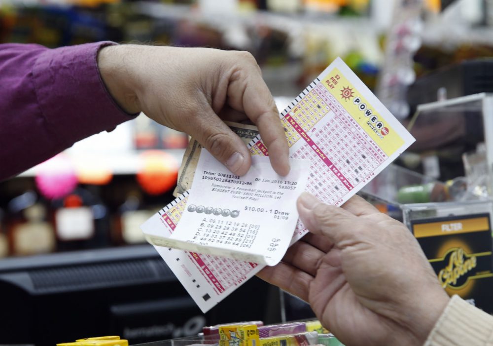 Money and Powerball tickets change hands at Pine Liquors in Fort Washington, Md., Friday, Jan. 8, 2016, for the upcoming Powerball drawing. (Alex Brandon/AP)