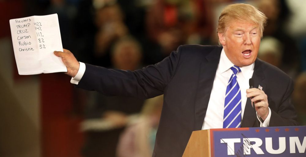 Republican presidential candidate Donald Trump shows off recent poll numbers during a campaign stop Tuesday in Claremont, N.H. (Jim Cole/AP)