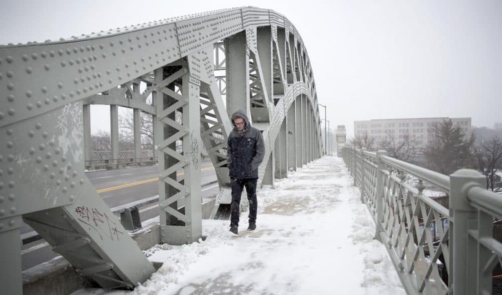 James Bridger, 22, crosses BU Bridge in Boston during Monday's storm. He's visiting Boston from the United Kingdom and when asked about the weather here, said, "I've seen better." (Robin Lubbock/WBUR)