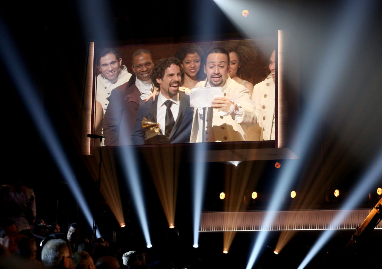 Lin-Manuel Miranda, right, appears on screen accepting the award for best musical theater album for Hamilton at the 58th annual Grammy Awards on Monday, Feb. 15, 2016, in Los Angeles. (Matt Sayles/Invision/AP)